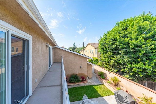 view of side of home featuring a fenced backyard, a patio, and stucco siding