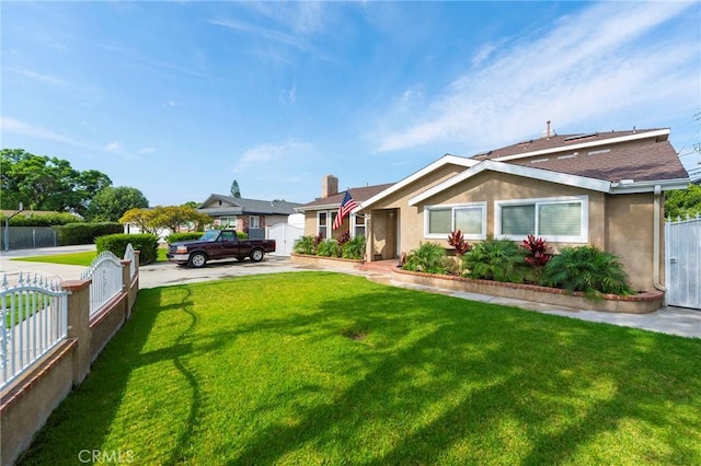 view of front of house featuring a fenced front yard, a front lawn, and stucco siding