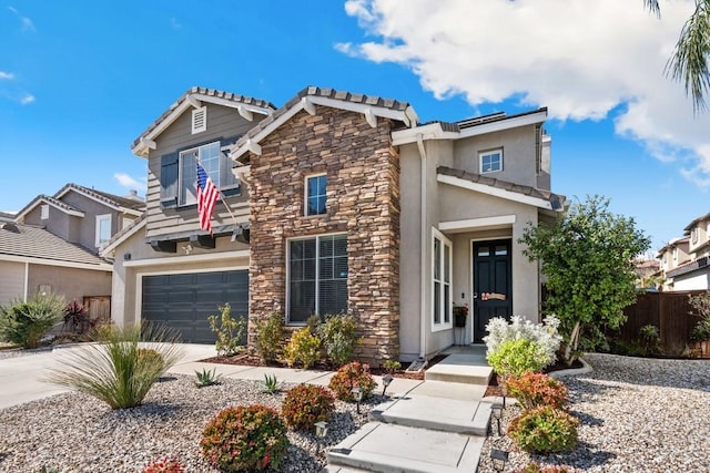 view of front of property featuring concrete driveway, stone siding, an attached garage, fence, and stucco siding