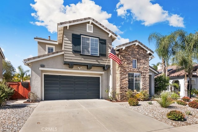 traditional home with stucco siding, concrete driveway, an attached garage, fence, and stone siding