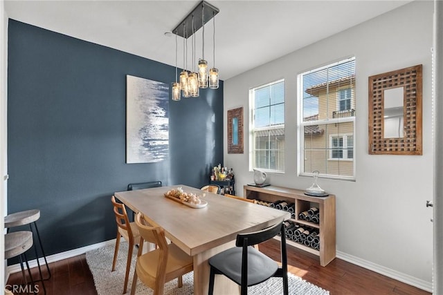 dining space featuring a notable chandelier, baseboards, and wood finished floors