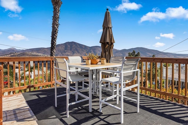 wooden deck with outdoor dining space and a mountain view