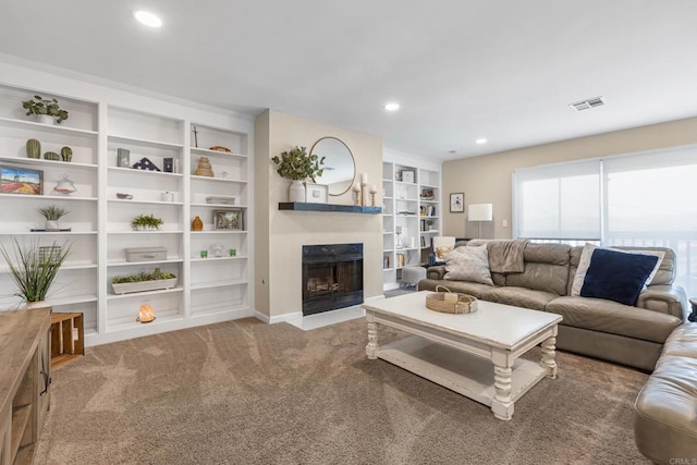 living room featuring built in shelves, carpet, recessed lighting, visible vents, and a fireplace with flush hearth