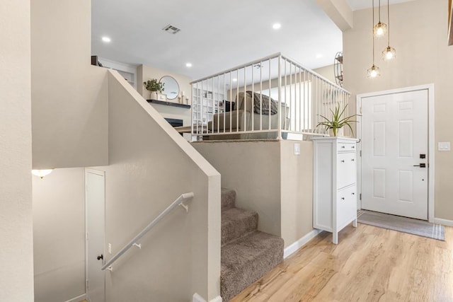 stairs with recessed lighting, visible vents, baseboards, and wood finished floors