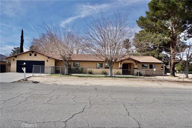 ranch-style home featuring a garage, concrete driveway, a fenced front yard, a tile roof, and stucco siding