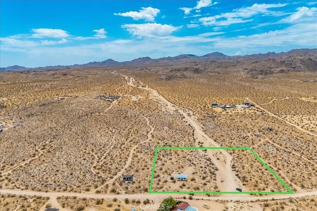 drone / aerial view featuring a mountain view and a desert view