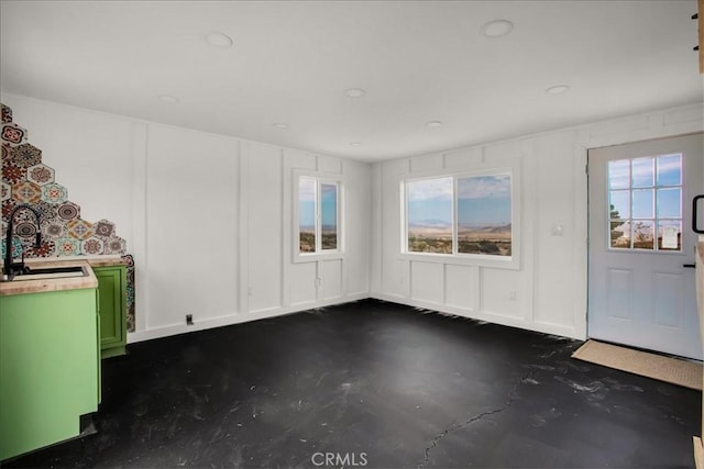 interior space featuring concrete floors and a decorative wall