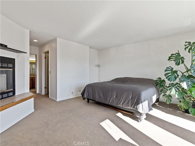 bedroom featuring recessed lighting, baseboards, a multi sided fireplace, and light colored carpet