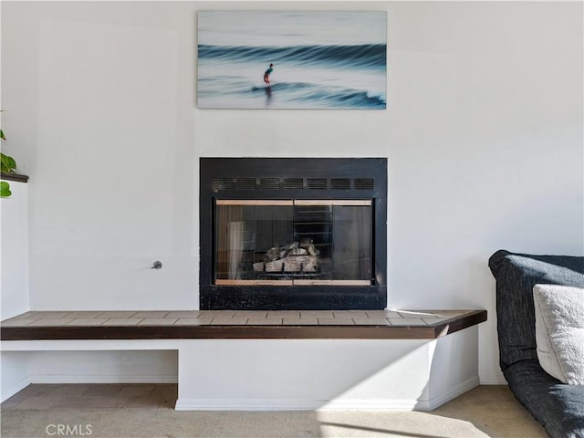 interior details featuring a fireplace, baseboards, and carpet flooring