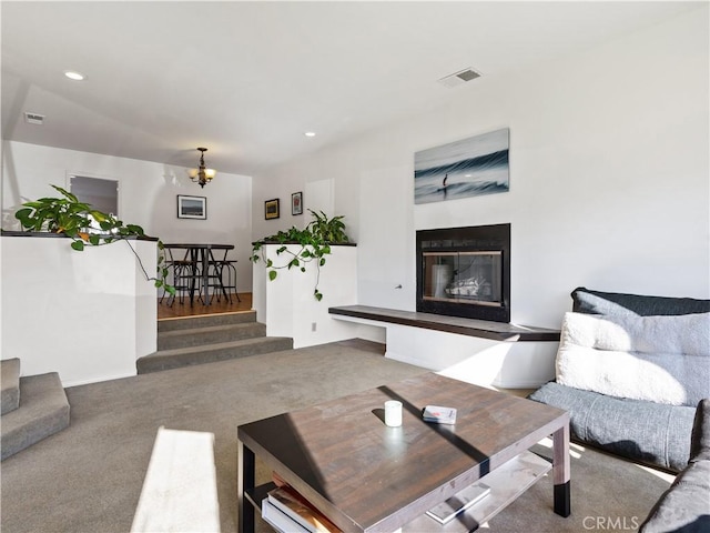 carpeted living room with recessed lighting, stairs, visible vents, and a glass covered fireplace