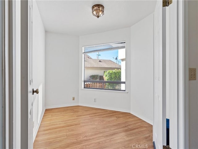 empty room with light wood-type flooring and baseboards