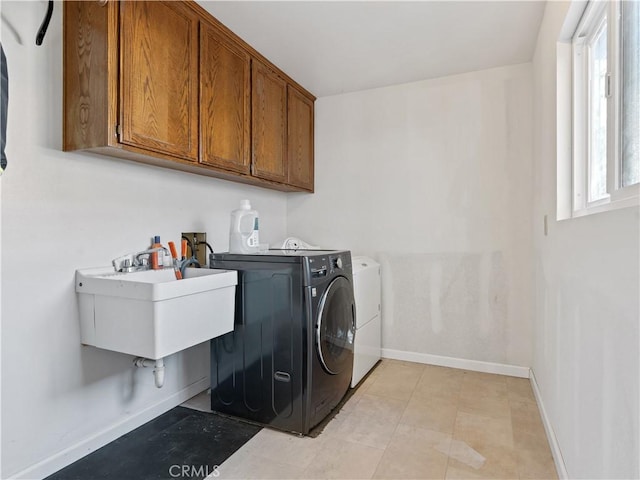laundry area with a sink, washing machine and clothes dryer, cabinet space, and baseboards