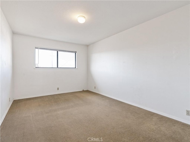 empty room with carpet and baseboards