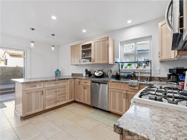 kitchen featuring light brown cabinets, stainless steel dishwasher, a sink, and glass insert cabinets