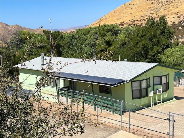 view of front of home featuring fence, a mountain view, and roof with shingles