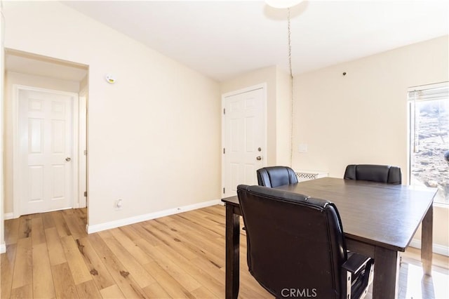 dining room with light wood-type flooring and baseboards