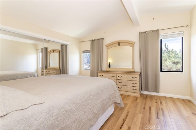 bedroom with lofted ceiling with beams, light wood finished floors, multiple windows, and baseboards