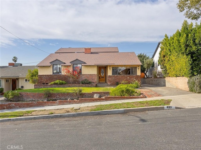 view of front of property featuring brick siding and a chimney