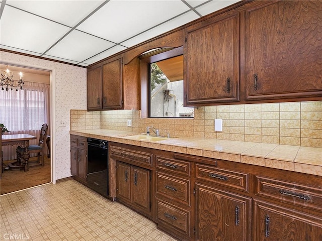 kitchen with dark brown cabinetry, wallpapered walls, tile counters, and a sink