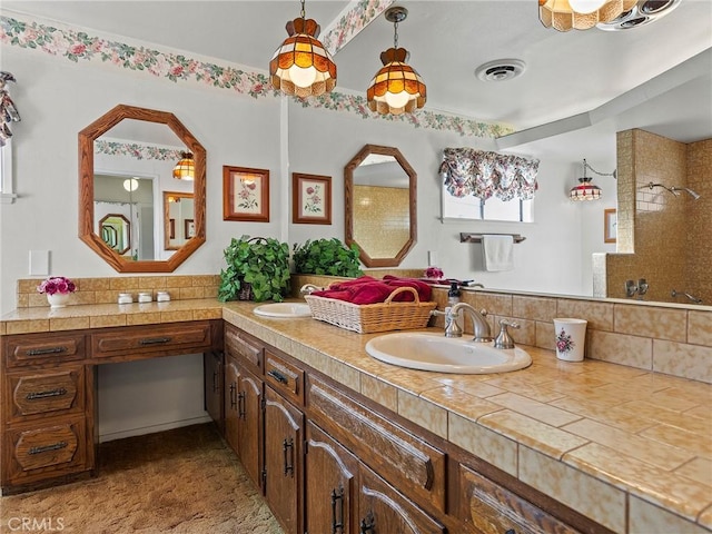 bathroom featuring double vanity, tasteful backsplash, visible vents, and a sink