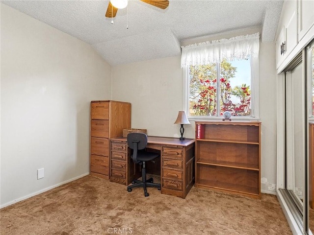 home office with lofted ceiling, ceiling fan, a textured ceiling, and light colored carpet