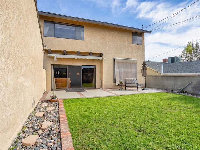 rear view of property with a yard, a patio, fence, and stucco siding