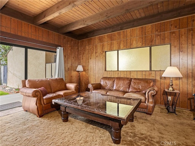 living area featuring wood walls, carpet flooring, and beam ceiling