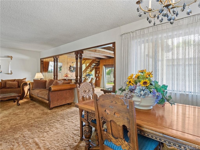 carpeted dining room featuring stairway and a textured ceiling