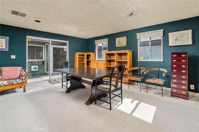 dining room featuring carpet, visible vents, and a textured ceiling