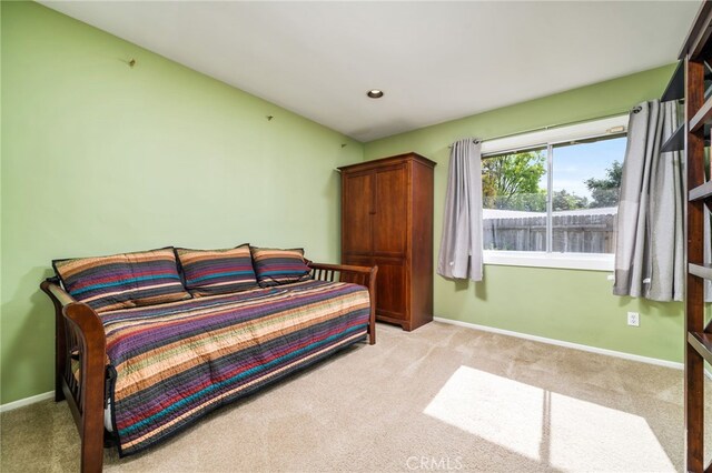 bedroom with light carpet and baseboards