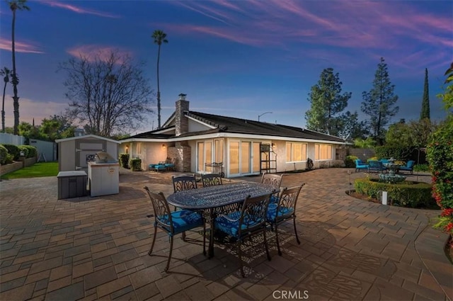 view of patio / terrace with an outbuilding, outdoor dining space, and a shed