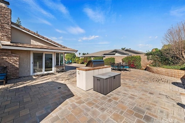 view of patio / terrace with area for grilling, fence, outdoor dry bar, grilling area, and outdoor dining space