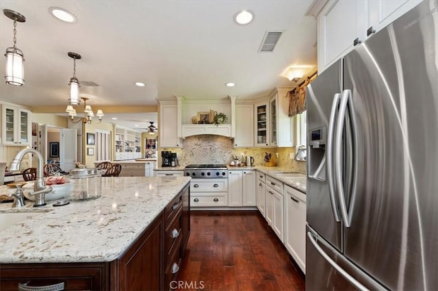 kitchen with glass insert cabinets, visible vents, appliances with stainless steel finishes, and pendant lighting