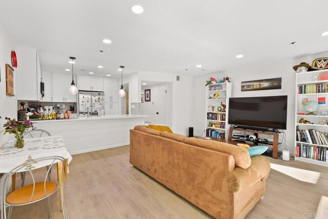 living room featuring light wood-style flooring and recessed lighting