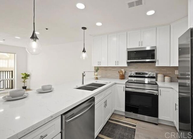 kitchen with stainless steel appliances, white cabinets, and recessed lighting