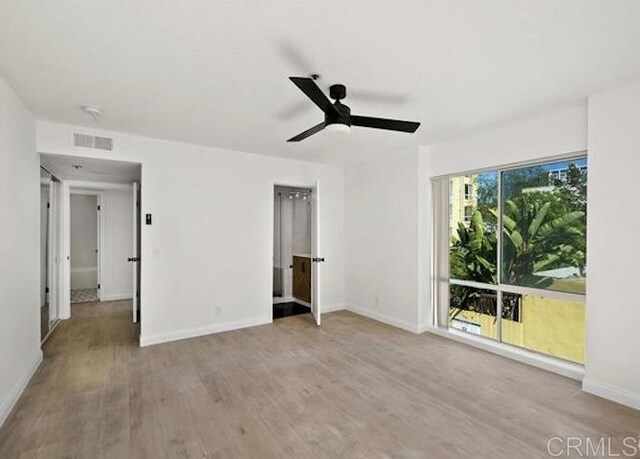 unfurnished bedroom featuring wood finished floors, baseboards, and ceiling fan