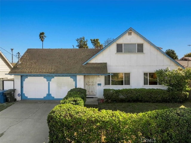 view of front facade with roof with shingles, driveway, and an attached garage