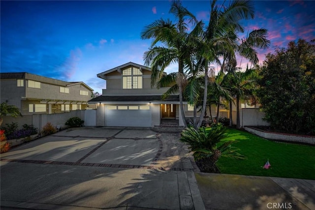 view of front of property with driveway, a garage, fence, and a yard