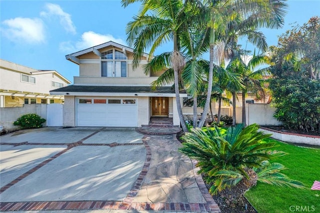 view of front of home with concrete driveway, brick siding, fence, and an attached garage