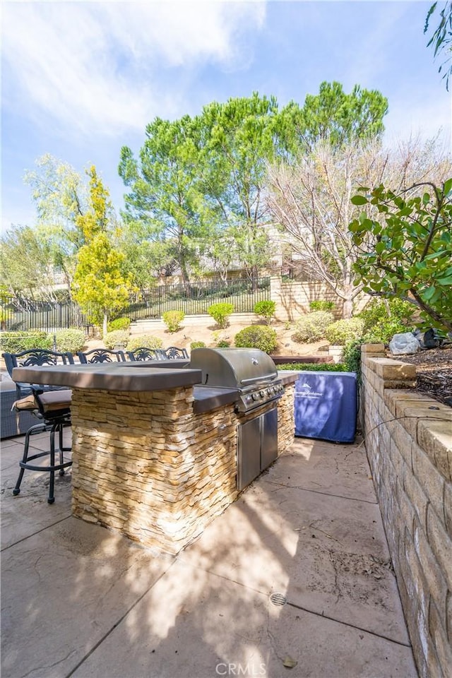 view of patio with a grill, an outdoor kitchen, and a fenced backyard