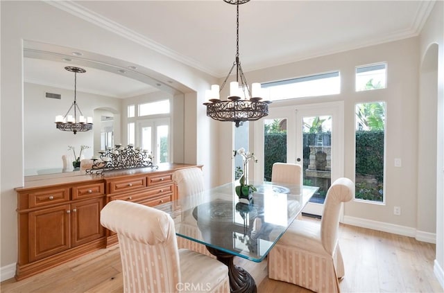 dining space with french doors, arched walkways, an inviting chandelier, and visible vents