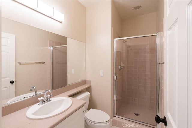 full bathroom featuring a shower stall, vanity, and toilet