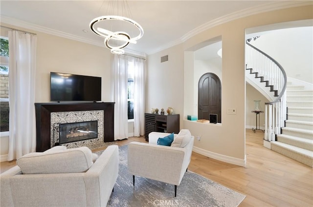living area with baseboards, an inviting chandelier, wood finished floors, and stairs