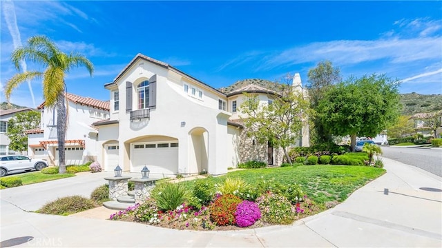 mediterranean / spanish-style home featuring stucco siding, an attached garage, and concrete driveway