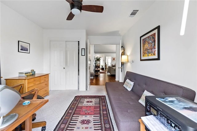 living area featuring ceiling fan and visible vents