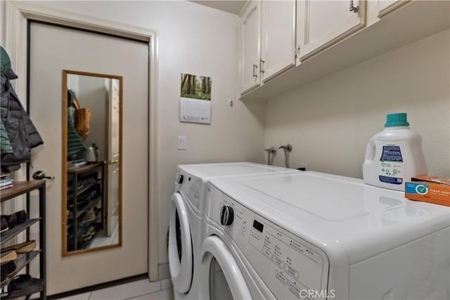 clothes washing area with light tile patterned floors, cabinet space, and separate washer and dryer