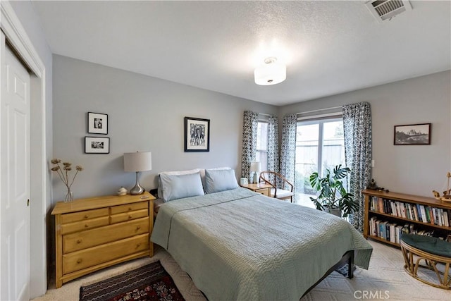 carpeted bedroom with visible vents and a closet