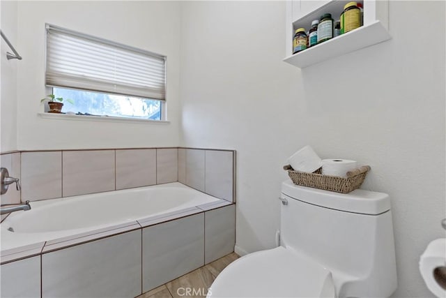 full bath featuring wood finished floors, toilet, and a bath