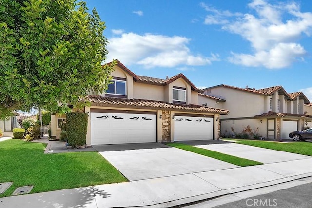 mediterranean / spanish house featuring stucco siding, concrete driveway, an attached garage, a front yard, and a tiled roof