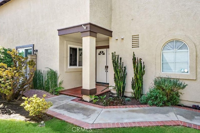 view of exterior entry with stucco siding